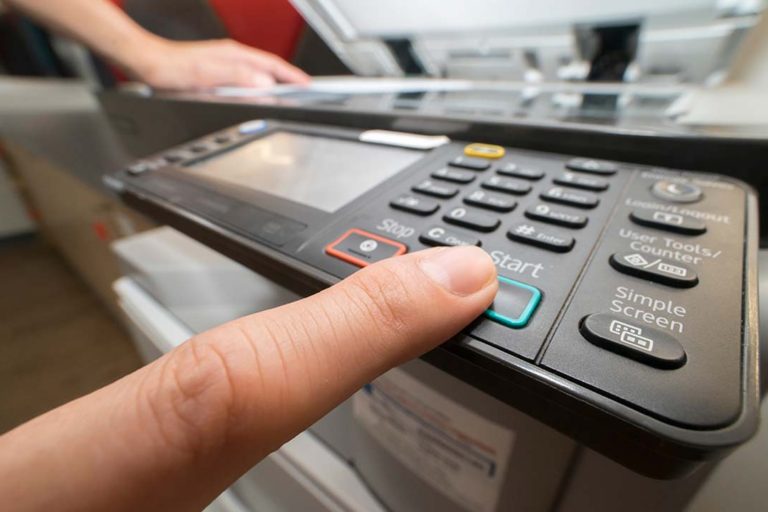 Man pushing copy button to copying paper from Photocopier
