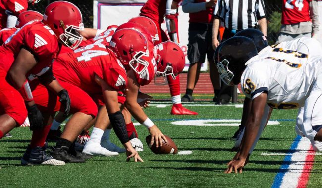 Football teams lined up for the snap of the ball